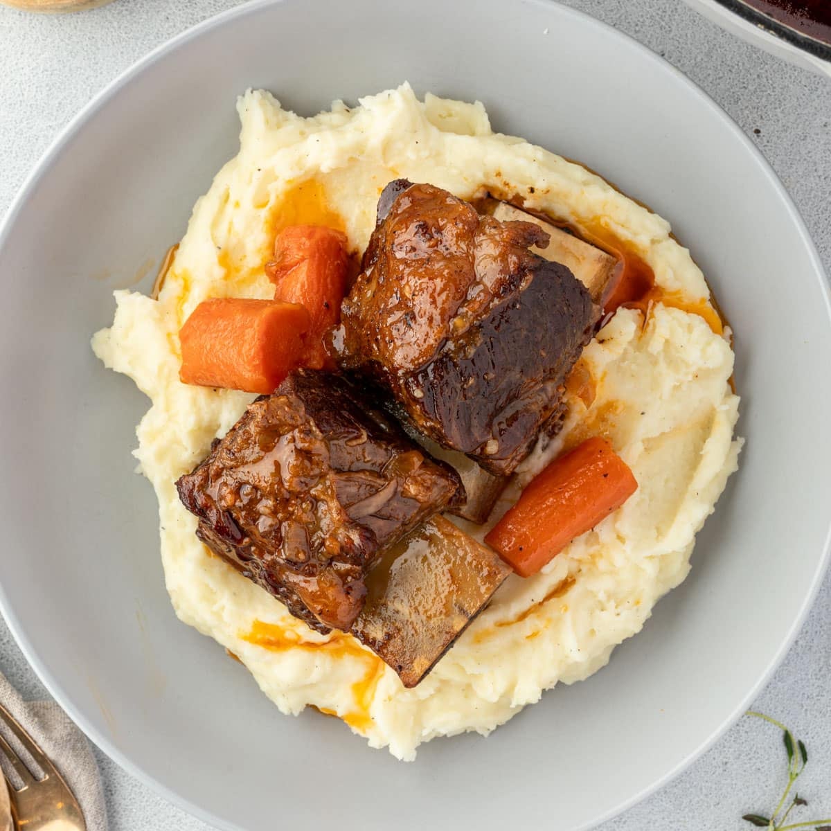 Beer-braised beef short ribs with carrots over mashed potatoes