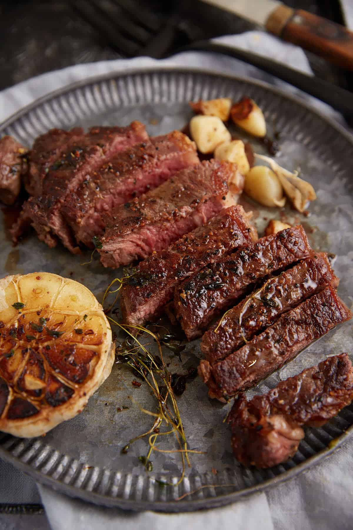 Cooked ribeye steaks seared with garlic, butter, and thyme